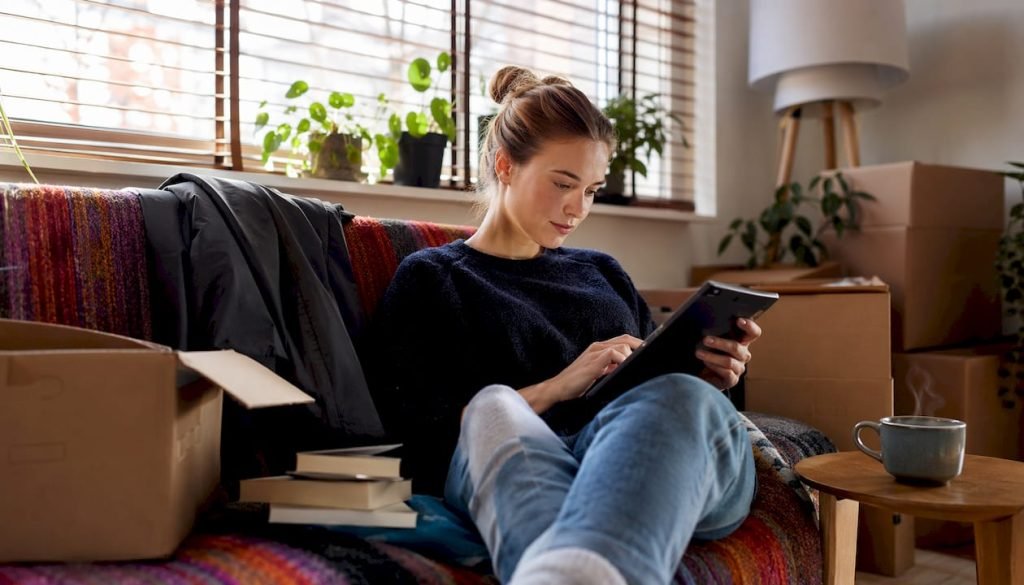 Vrouw vraagt via haar tablet een offerte voor een verhuizing aan