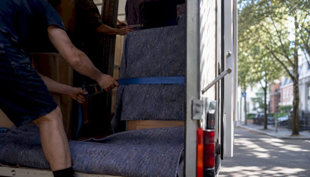 Verhuizers zetten het meubilair stevig vast in de verhuiswagen.