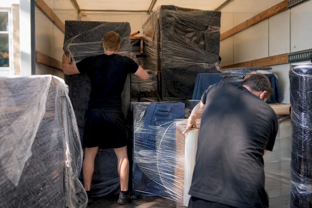 Meubels inladen met verhuisdekens en folie in een verhuiswagen