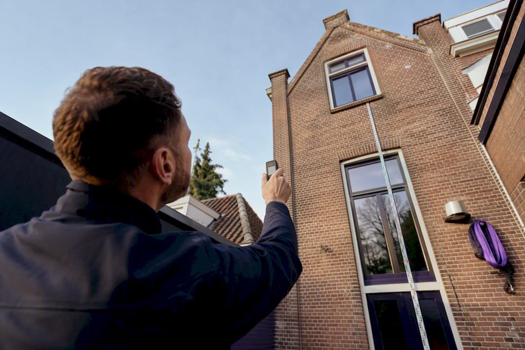 De hoogte van een raam bij een oud pand opmeten