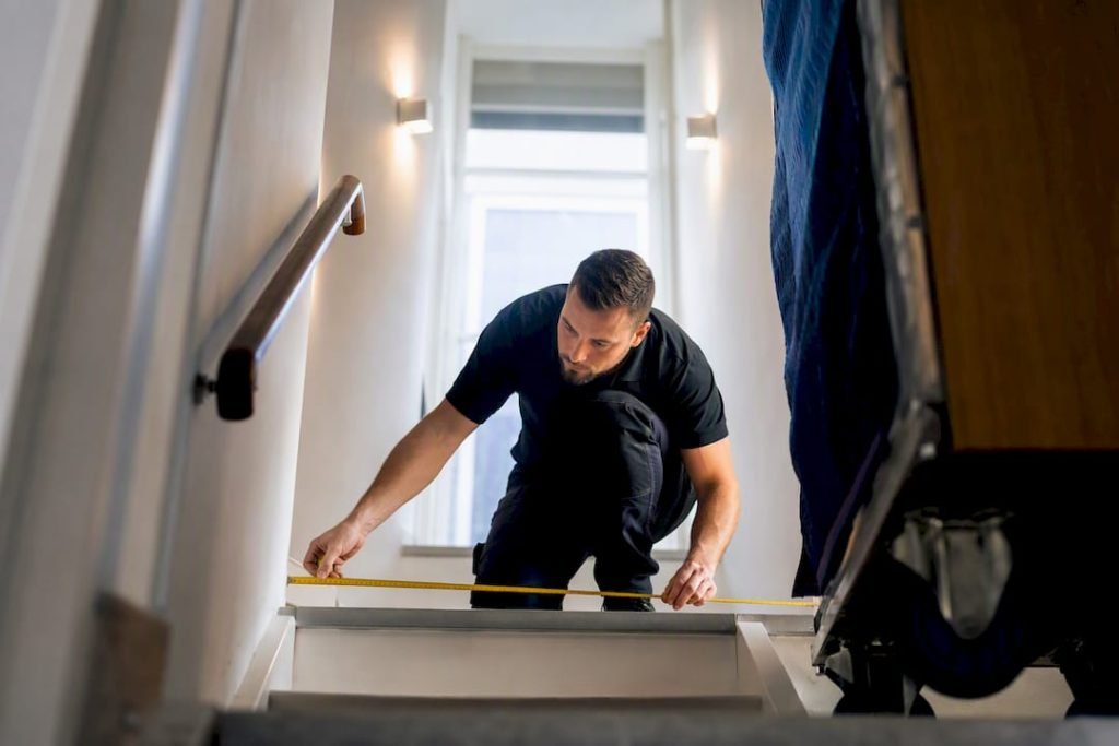 Verhuizer bekijkt smalle trap tijdens verhuisinspectie