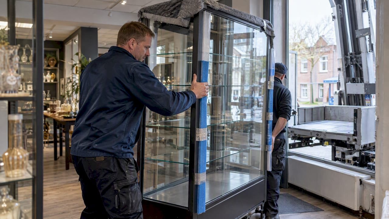 Vitrinekast wordt met verhuislift afgevoerd